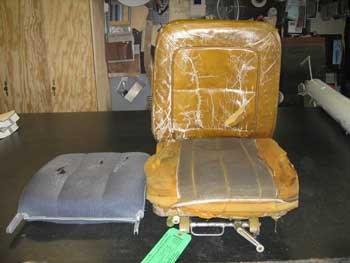 Seat with cushions in need of repair.
