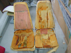 Seat with cushions in need of repair.