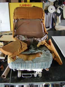 Seat with cushions in need of repair.