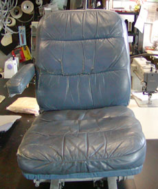 Seat with cushions in need of repair.